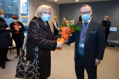 Ráðuneytisstjóri heilbrigðisráðuneytis afhendir forstjóra spítalans blóm við opnun endurgerðra Eiríksstaða