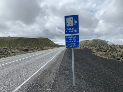 Skilti um sjálftvirkt meðalhraðaeftirlit í Grindavík.