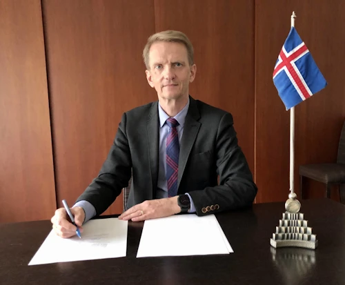 Haraldur Aspelund fastafulltrúi Íslands í Genf skrifar undir samninginn fyrir Íslands hönd.
